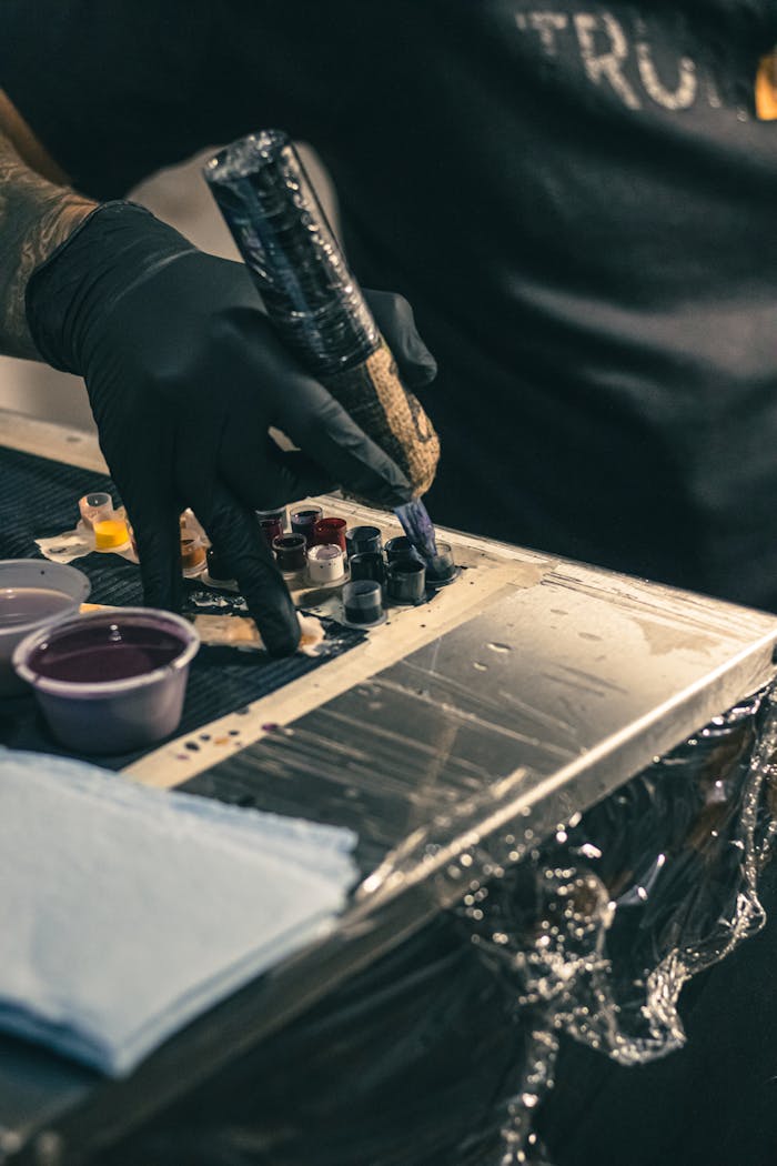 Tattoo artist prepares colors during inking session at Ciudad de México studio.