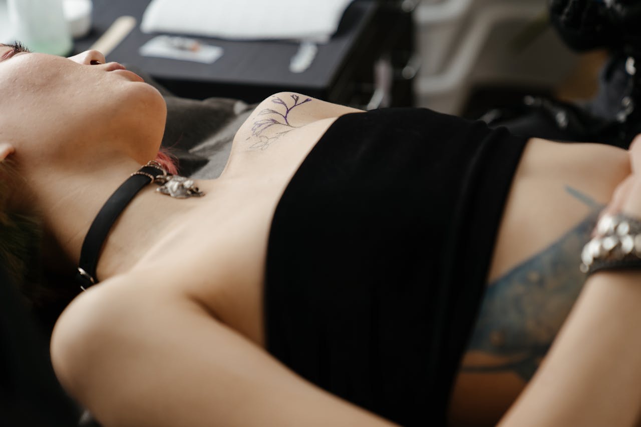 Close-up of a female getting a tattoo in a studio setting, showcasing the design process.